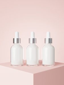 Cosmetic serum dropper bottles on podium with pastel pink background 3D render, care product packaging and branding
